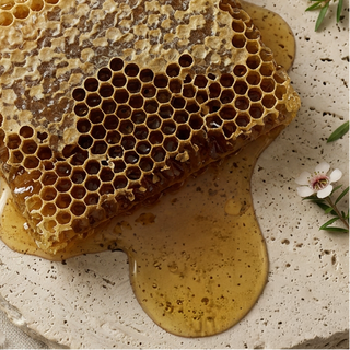 Honeycomb with honey on a stone surface with a wooden dipper